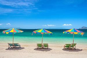férias de verão coloridas cadeiras de praia com guarda-sóis, ilha de phuket, tailândia foto