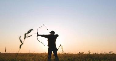 homem com arco ao ar livre no campo foto