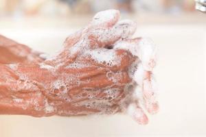 mulheres idosas lavando as mãos com sabão água morna foto