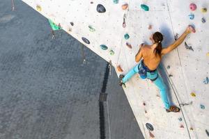 um homem está escalando uma parede de escalada foto