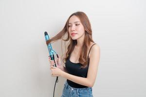 retrato de uma linda mulher asiática usando modelador de cabelo ou modelador de cachos foto