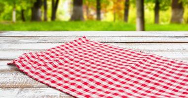 toalha de mesa quadriculada vermelha em uma mesa vazia - vista de cima foto