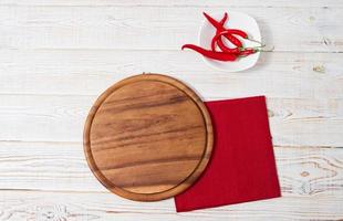 mesa de pizza vazia, chili peper e guardanapo vermelho na vista de cima da mesa de madeira