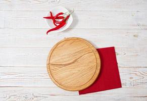 mesa de madeira, guardanapo vermelho, pimenta vermelha na mesa. conceito de férias de mesa de mesa
