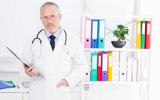 médico com pasta posando no consultório médico da clínica foto