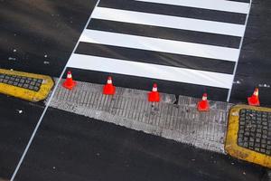 Cruzamento de zebra recém-pintado em uma estrada da cidade com cones e fita adesiva no asfalto