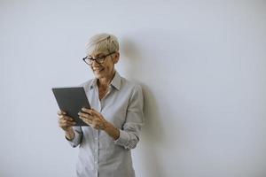 mulher madura usando tablet digital no escritório foto