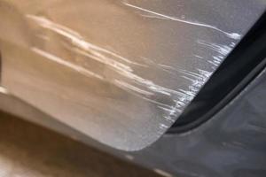arranhar a porta do carro cinza com danos no acidente