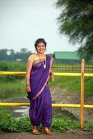 linda jovem indiana em sari tradicional posando ao ar livre foto