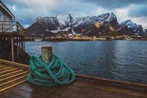 corda natical spriral em um píer de madeira no fundo de montanhas e paisagens nas ilhas lofoten. lugar para texto ou publicidade foto