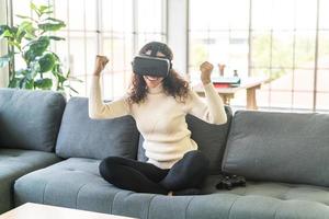 mulher latina usando um fone de ouvido de realidade virtual no sofá