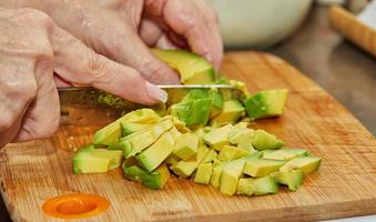 cozinheiro corta abacate maduro em fatias para fazer salada