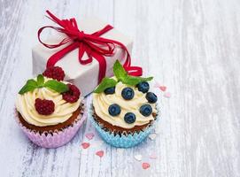 cupcakes com frutas frescas e caixa de presente foto