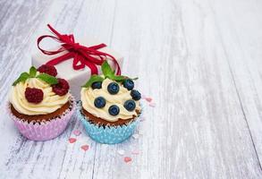 cupcakes com frutas frescas e caixa de presente foto