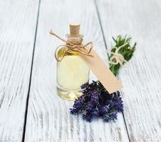 garrafa com óleo, etiqueta vazia e flores de lavanda foto