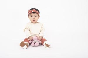 adorável menina asiática é retrato em fundo branco foto