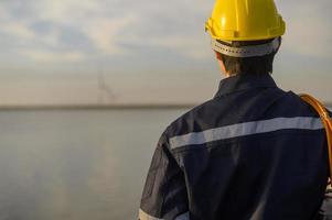 um engenheiro masculino usando um capacete protetor ao pôr do sol. foto