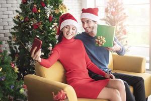 atraente casal caucasiano de amor está comemorando o natal em casa foto