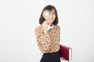mulher asiática atraente está segurando um livro sobre fundo branco foto