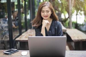 mulher asiática inteligente está trabalhando com computador portátil foto