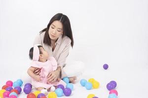 mãe asiática e adorável menina estão felizes em fundo branco foto