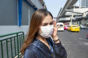 linda mulher usando máscara anti-poeira protege a poluição do ar e pm 2.5 na cidade de rua foto