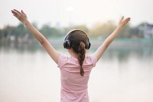 linda mulher está ouvindo música no parque foto