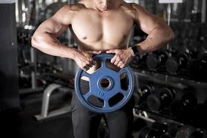 close-up homem musculoso é exercício no ginásio de fitness foto