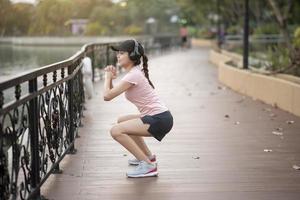 linda mulher está ouvindo música e exercício no parque foto