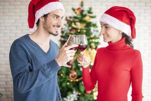 atraente casal caucasiano de amor está comemorando o natal em casa foto