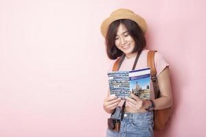 turista de mulher asiática feliz em fundo rosa foto