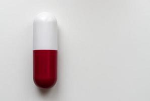 comprimido grande cápsula vermelha e branca isolado no fundo branco. conceito de farmácia. copie o espaço. foto