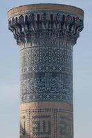 closeup do topo da torre com um mosaico de edifícios asiáticos bastante antigos. os detalhes da arquitetura da ásia central medieval foto