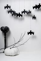 dia das bruxas com silhuetas negras de morcegos e abóboras com um galho de uma árvore em um fundo branco foto