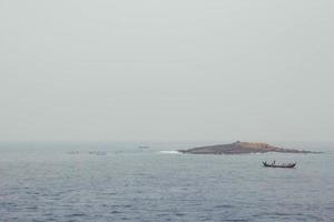 pescadores asiáticos em um barco de madeira navegam no meio do mar. copiar, espaço vazio para texto foto