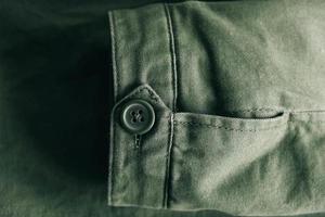fundo de manga dobrável de jaqueta verde e botão com linha de costura foto