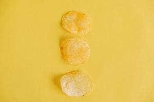 três batatas fritas em um fundo amarelo