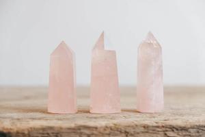 cristais polidos pedra preciosa de quartzo rosa em uma mesa de madeira