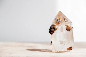 cristal de quartzo esfumaçado em uma superfície de madeira em um fundo branco