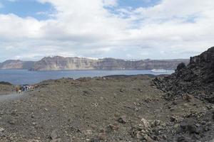 estrada rochosa exótica para a cratera do vulcão. o vulcão está localizado na famosa caldeira de santorini. foto
