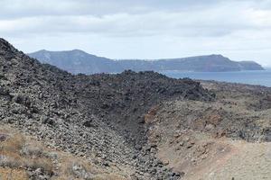 estrada rochosa exótica para a cratera do vulcão. o vulcão está localizado na famosa caldeira de santorini. foto