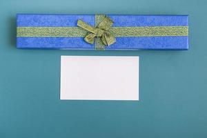 caixa de presente com gravata e cartão em um fundo turquesa. closeup de presentes de feriado com espaço de cópia foto