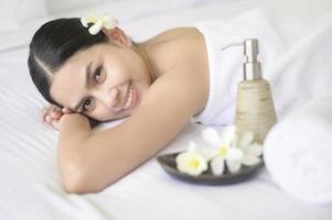 uma linda mulher está relaxando e fazendo massagem no conceito de spa resort, massagem e tratamento de beleza. foto