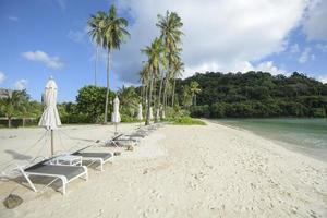 bela vista paisagem de espreguiçadeiras na praia tropical, o mar esmeralda e areia branca contra o céu azul, maya bay na ilha phi phi, tailândia foto