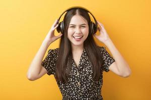 mulher amante da música está desfrutando com fone de ouvido em fundo amarelo foto