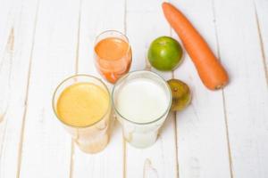 Suco de frutas e legumes dieta saudável pronto para beber na mesa de madeira foto