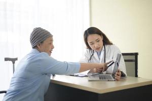 mulher paciente com câncer usando lenço na cabeça após consulta de quimioterapia e médico visitante no hospital. foto