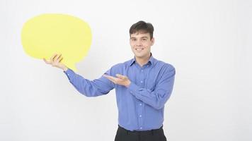 um homem de meia idade caucasiano está segurando um discurso vazio amarelo sobre fundo branco foto