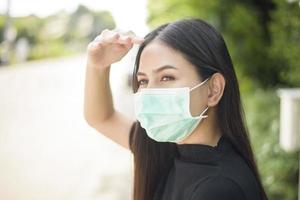 jovem está usando máscara facial na cidade ao ar livre foto