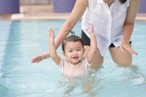 uma feliz mãe e filha asiáticas gostam de nadar na piscina, estilo de vida, paternidade, conceito de família foto